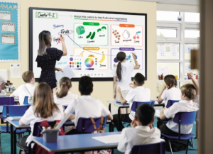 teacher and student write something on interactive flat panel display and all students sit front of interactive flat panel in the classroom